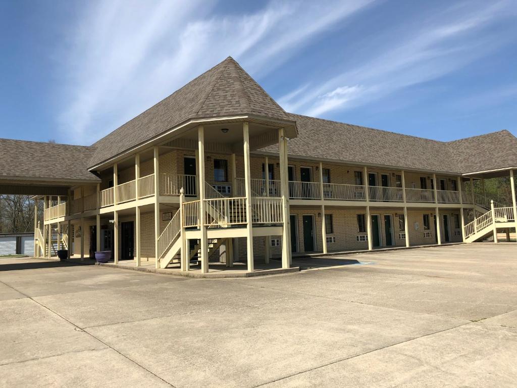 ein großes Gebäude mit einer Veranda und einem Dach in der Unterkunft Riverwood Inn in Glenwood