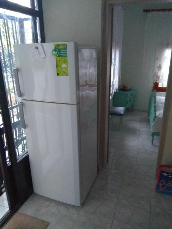 białą lodówkę w kuchni z pokojem w obiekcie Sofia's Cottage w mieście Asprovalta
