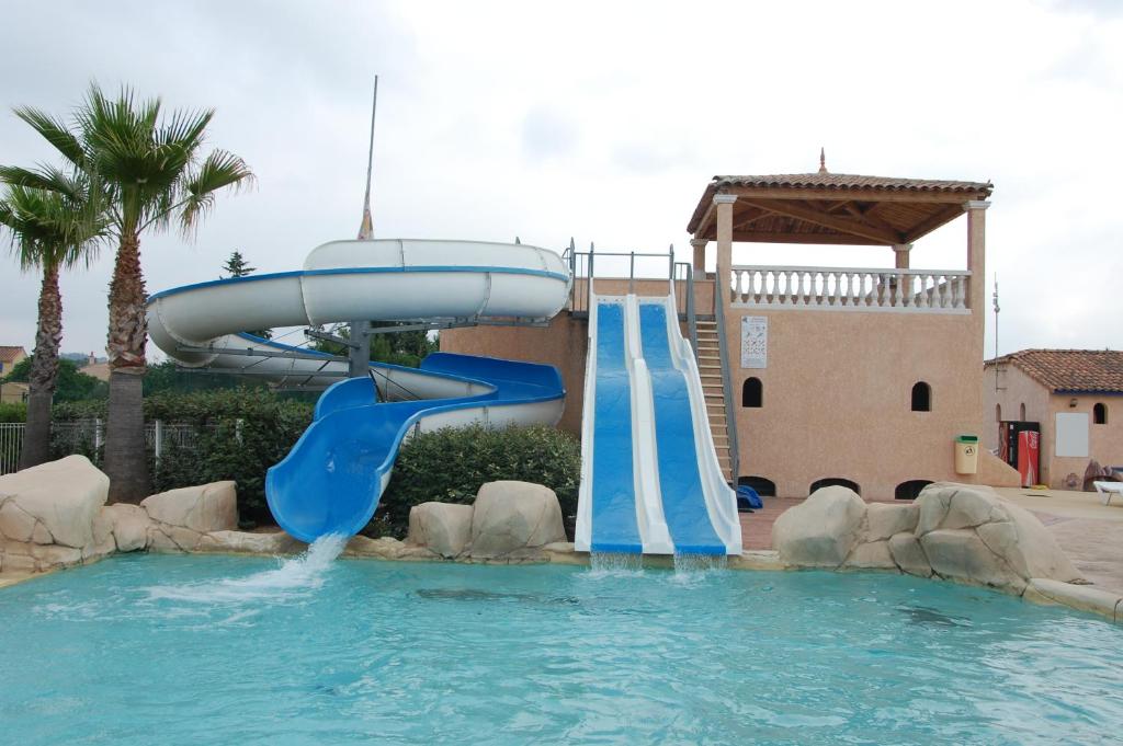 a water slide in a swimming pool in a resort at Résidence Niccola in Vidauban