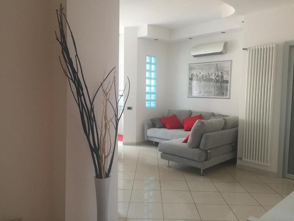 soggiorno con divano e cuscini rossi di Appartamento Ca’ del Gian a La Spezia