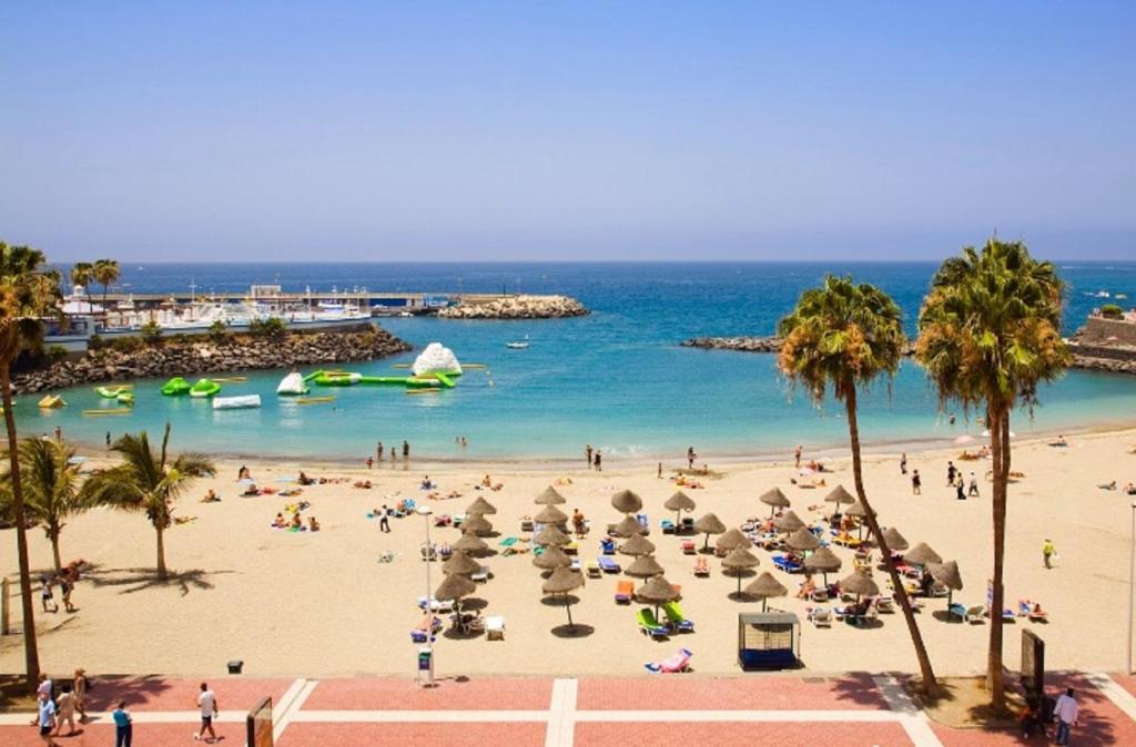アデへにあるPlaya y sol !!! Parking y wifi gratisの人と傘と海のビーチ