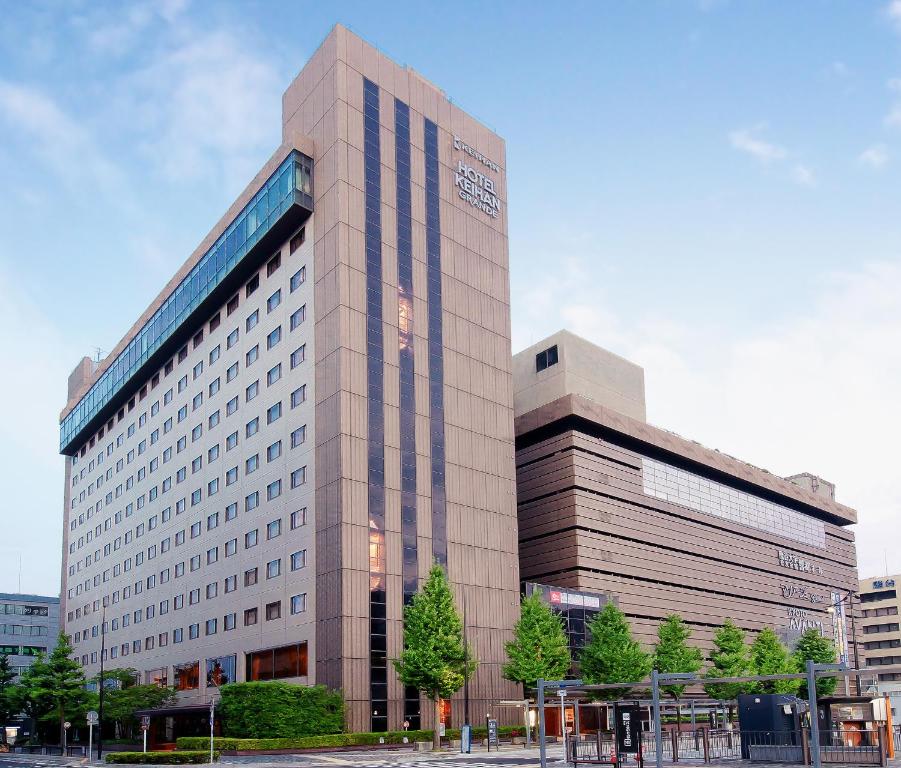 a large building in a city with trees in front at Hotel Keihan Kyoto Grande in Kyoto