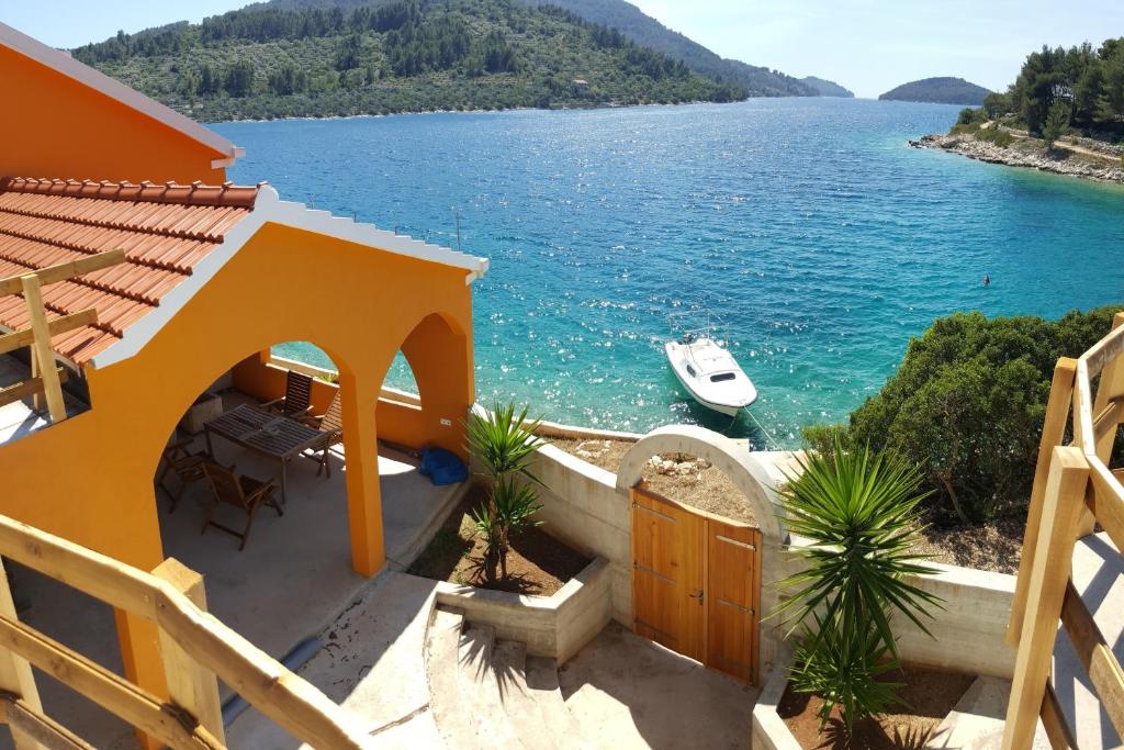 ein Haus mit Blick auf das Wasser und ein Boot in der Unterkunft Casa Naranja Croatia in Vela Luka