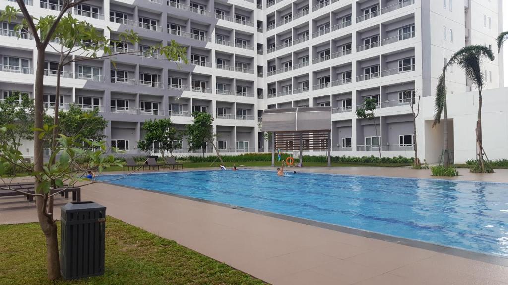 une grande piscine en face d'un bâtiment dans l'établissement Staycation at Grace Condo Near BGC, à Manille