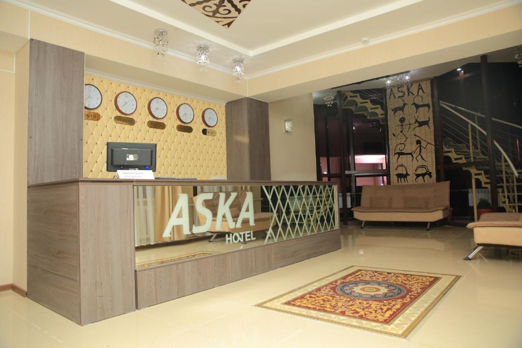 a lobby with a desk and clocks on the wall at Aska Hotel in Naryn