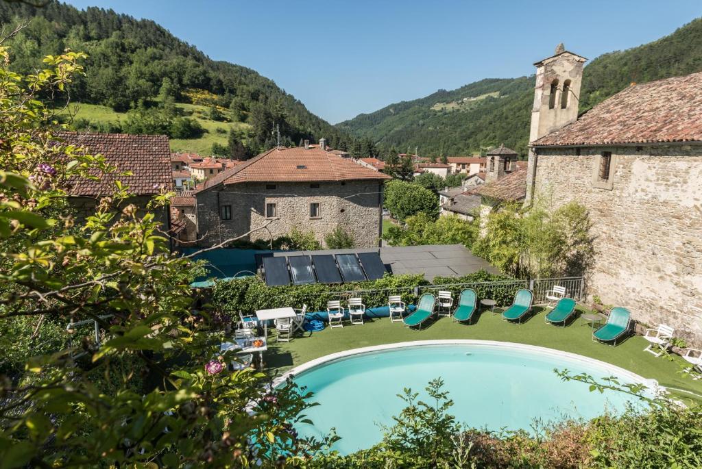 a swimming pool in front of a building with mountains at Albergo Diffuso Locanda Senio in Palazzuolo sul Senio