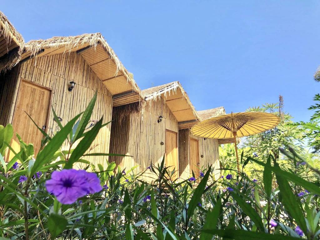 an umbrella and flowers in front of a building at Lanna House Lanna Hut Chiangmai in Chiang Mai