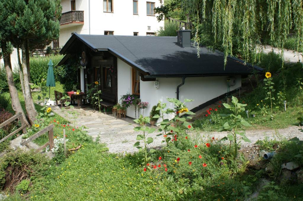 a small house with a black roof and a garden at Ferienwohnungen Wilhelmer in Liesing