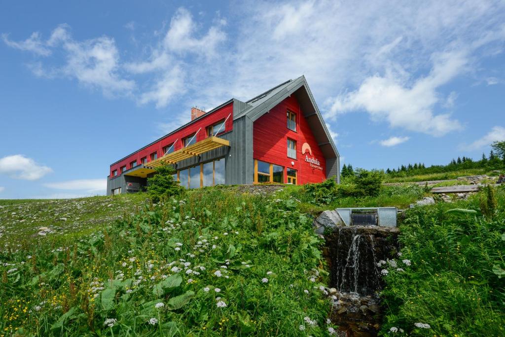 a red house on top of a hill at Penzion Andula Friesovy boudy in Strážné