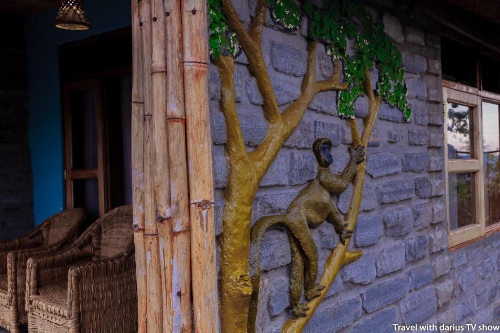 a statue of a monkey climbing a tree on the side of a building at Kyaninga Royal Cottage in Fort Portal