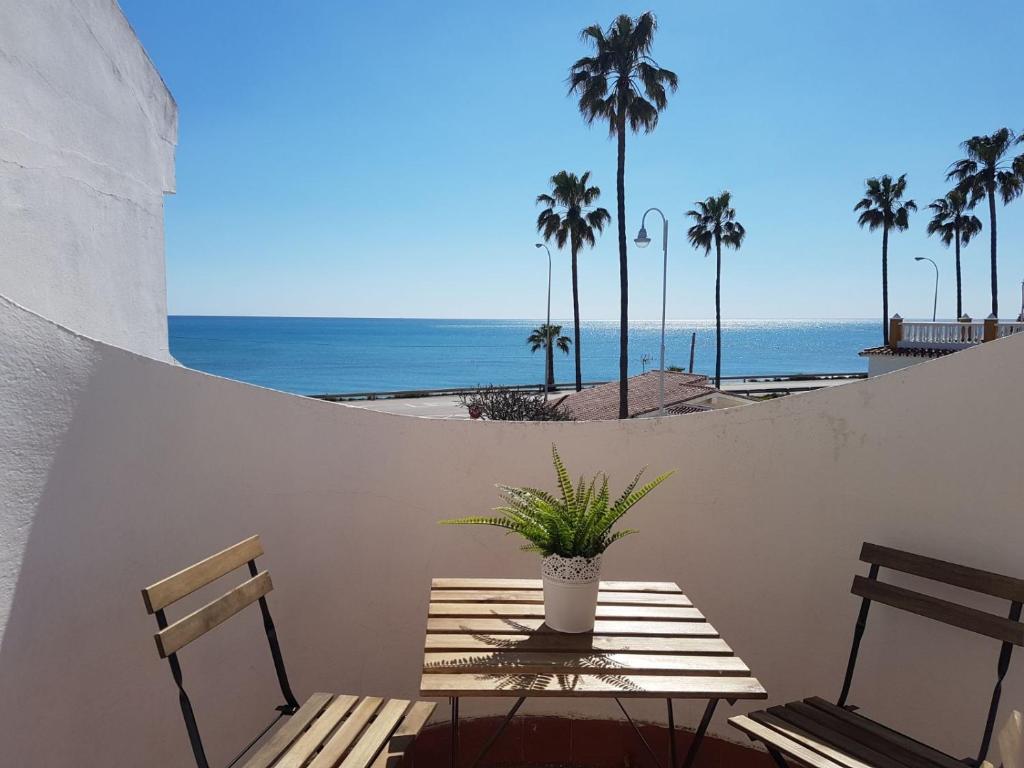 a patio with a table and two chairs and the ocean at Casa Las Toro Playa in Chilches