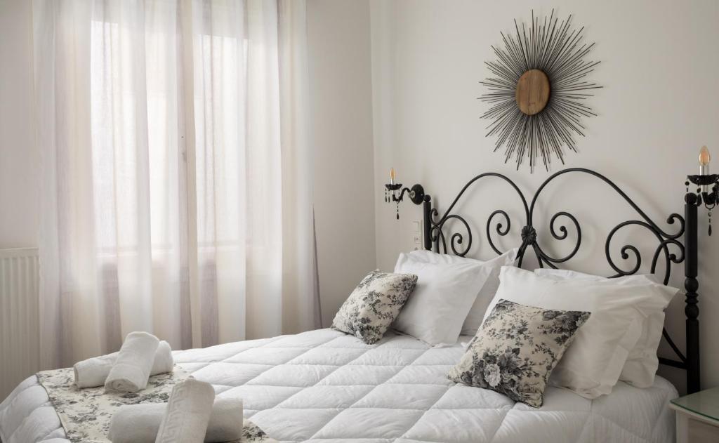a white bedroom with a large bed with white pillows at Relax Studios in Naxos Chora