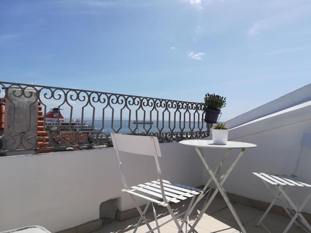 balkon z 2 krzesłami, stołem i ogrodzeniem w obiekcie Little River View Triplex in Alfama w Lizbonie