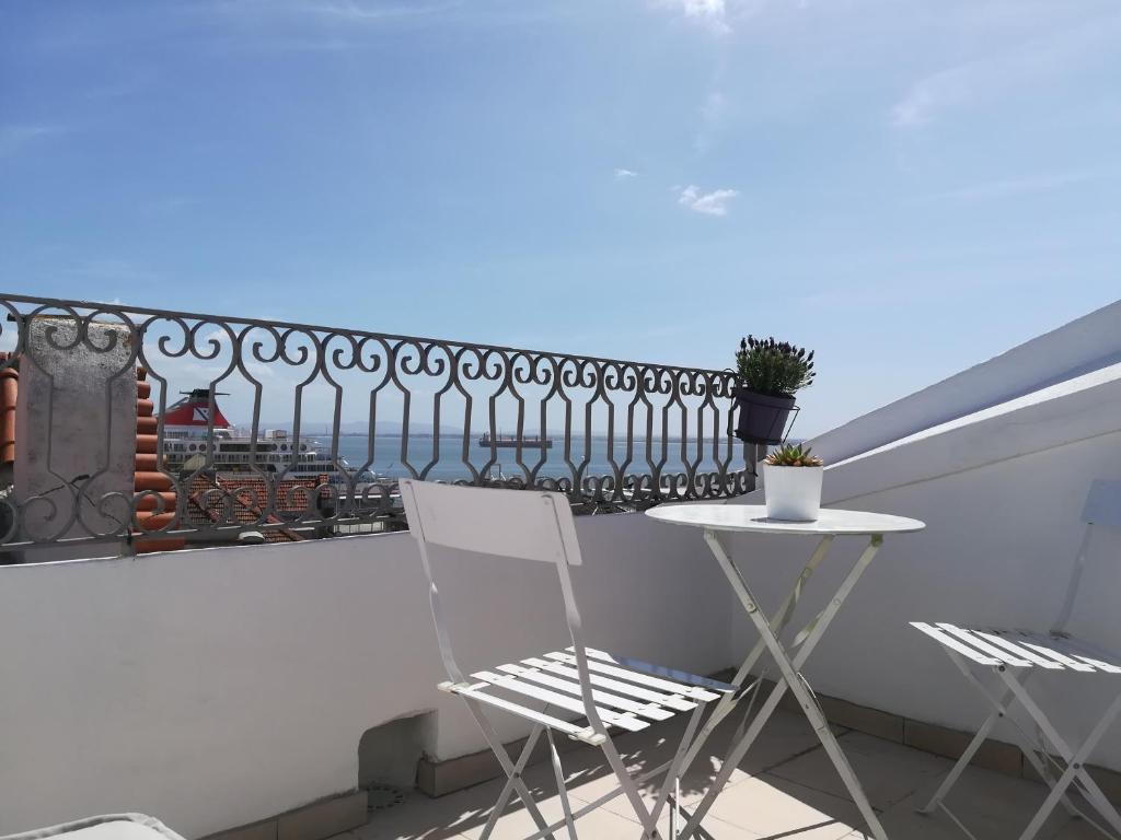 een balkon met 2 stoelen, een tafel en een hek bij Little River View Triplex in Alfama in Lissabon