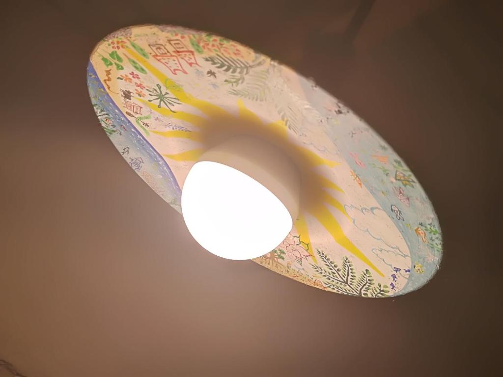 a ceiling light with a bird on the top of it at Taketomijima Guesthouse and je Taime in Taketomi
