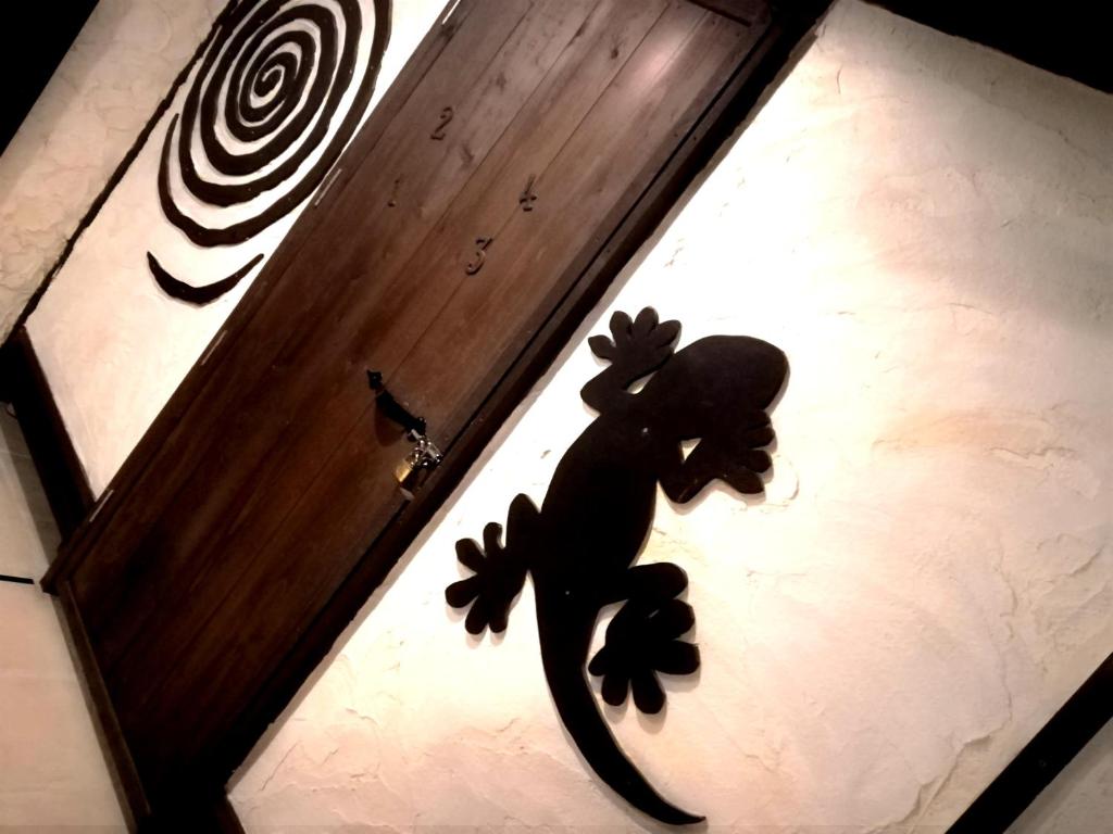 a black toy lizard on the door of a room at Taketomijima Guesthouse and je Taime in Taketomi