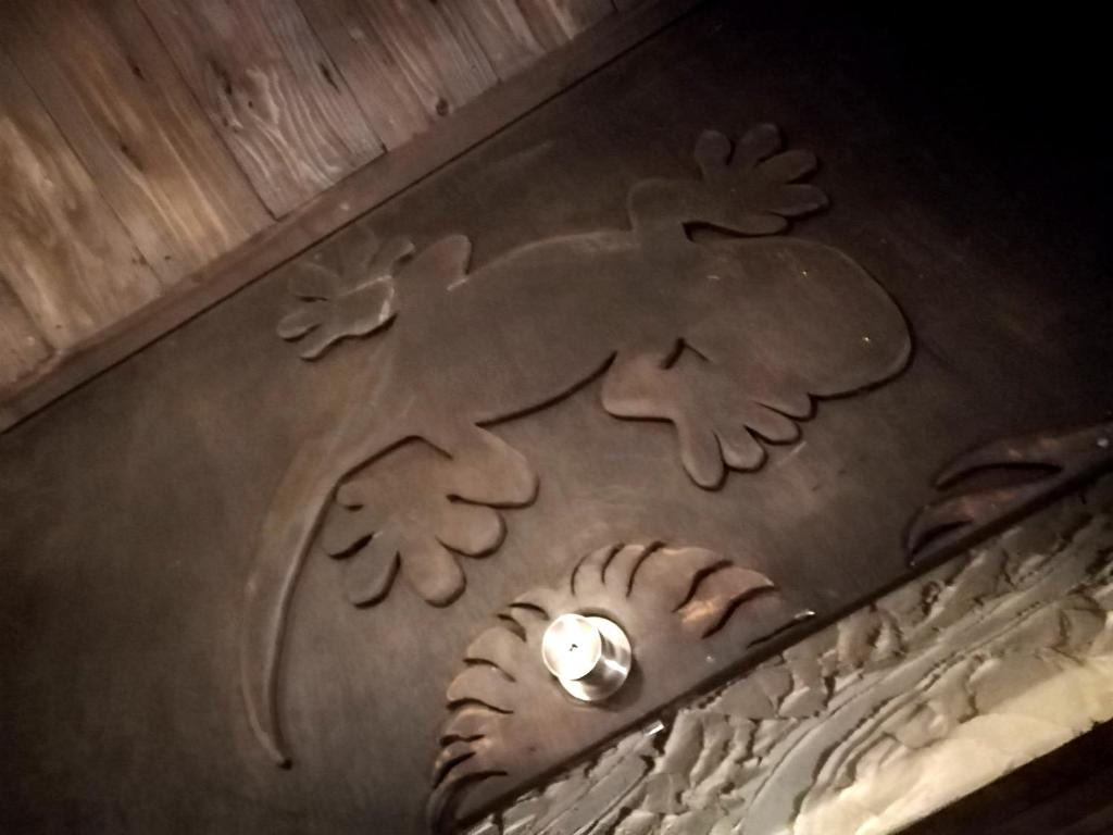 a wooden floor with a carving of an animal on it at Taketomijima Guesthouse and je Taime in Taketomi
