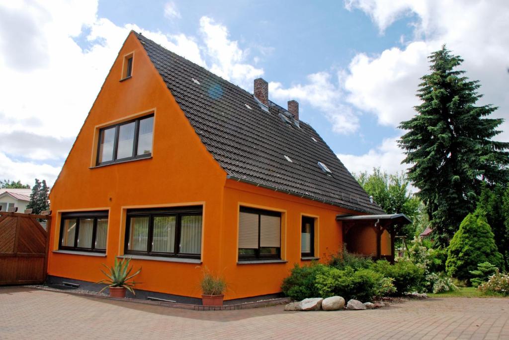 オストゼーバート・ゼリンにあるSelliner Ferienwohnungenの黒屋根のオレンジ色の家