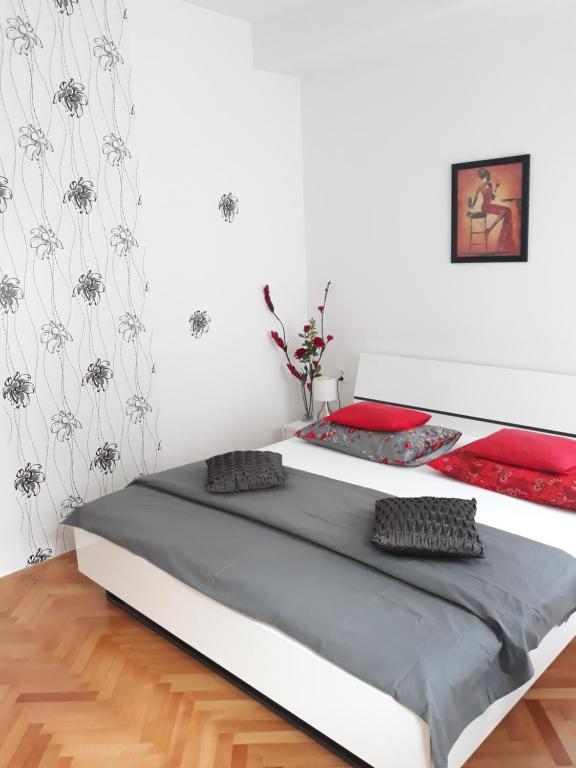 a bedroom with a large bed with red pillows on it at Rooms Miletic near the Palace in Split