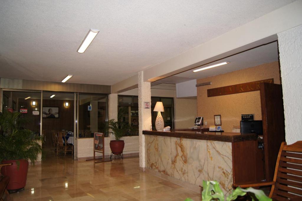 a lobby with a bar in a hotel with a table at Hotel Veracruz in Oaxaca City