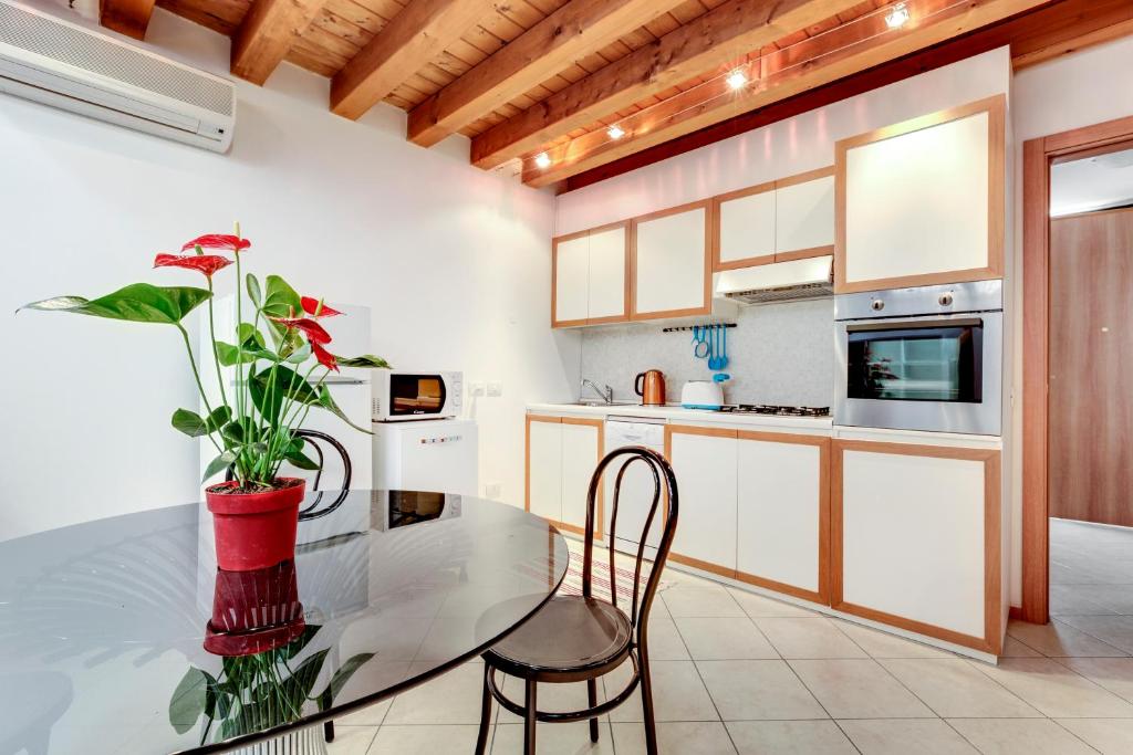 uma cozinha com uma mesa de vidro e um vaso com uma planta em Little Canal 19 em Veneza