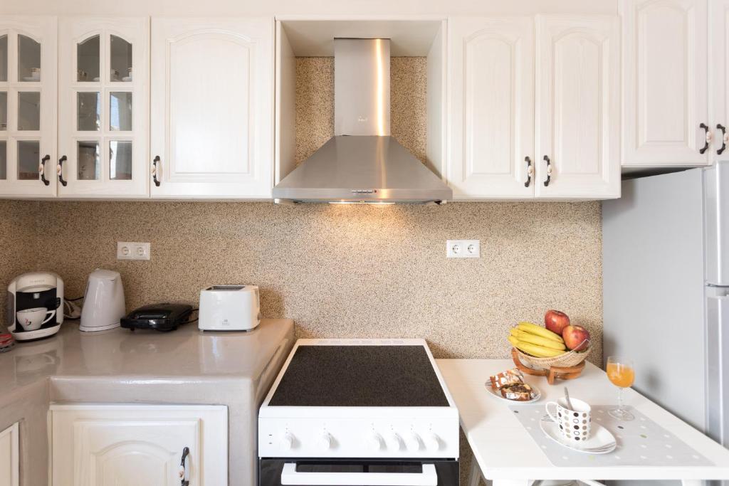 a kitchen with white cabinets and a stove top oven at Relax Studios in Naxos Chora