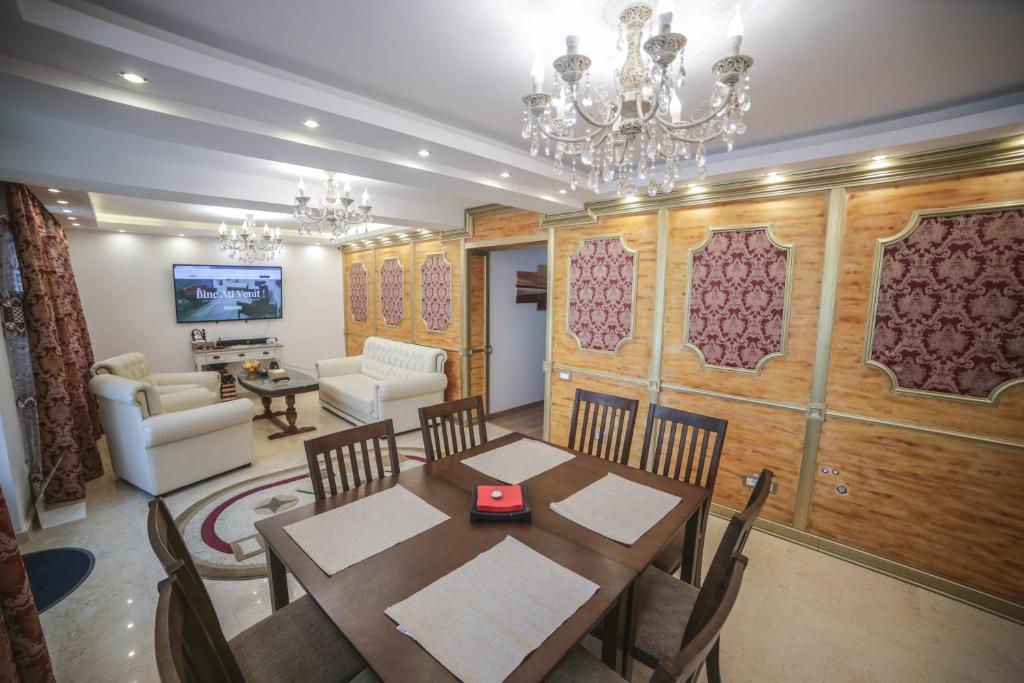 a dining room with a table and chairs and a living room at Studio B in Buftea