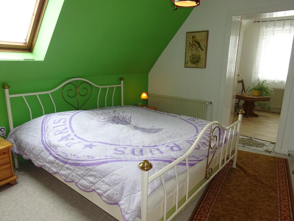 a bedroom with a white bed with a purple comforter at Ostseenähe Homestay in Gadebusch