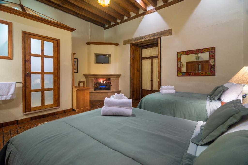 Postel nebo postele na pokoji v ubytování Hotel Casa del Naranjo