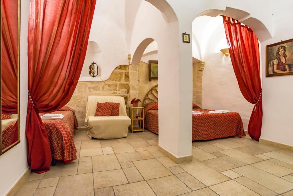 a bedroom with two beds and red curtains at B&B Borgo San Martino in Monopoli