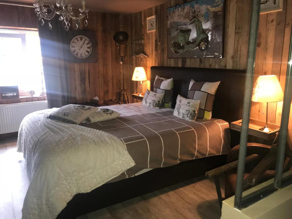 een slaapkamer met een bed en een klok aan de muur bij Le Relais de Chassepierre in Chassepierre