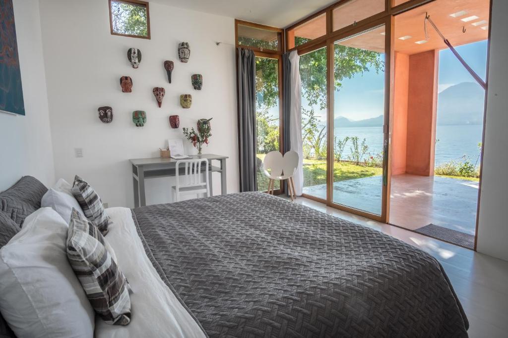 a bedroom with a bed and a view of the ocean at Anzan Atitlan in San Marcos La Laguna
