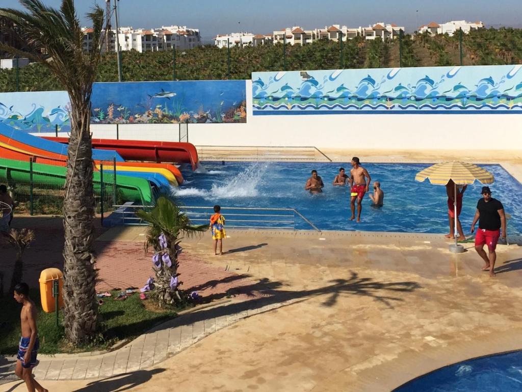 a group of people in a pool at a water park at Marina Golf Appart Chez Hicham in Asilah