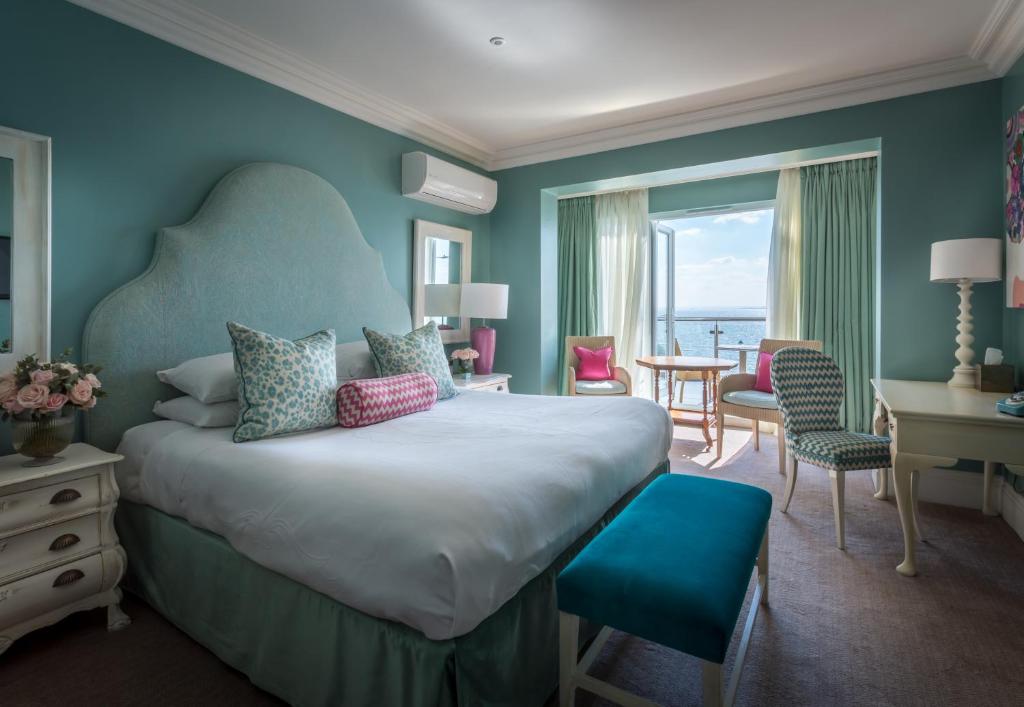 a bedroom with a large bed with a blue wall at Roslin Beach Hotel in Southend-on-Sea