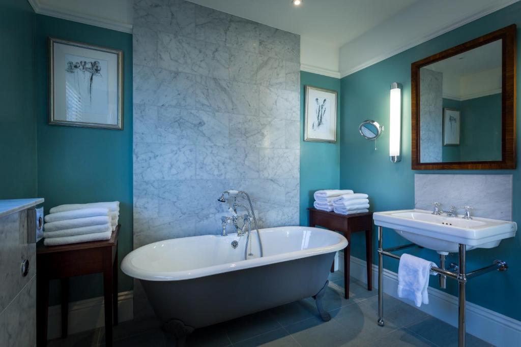 a bathroom with a tub and a sink at Roslin Beach Hotel in Southend-on-Sea