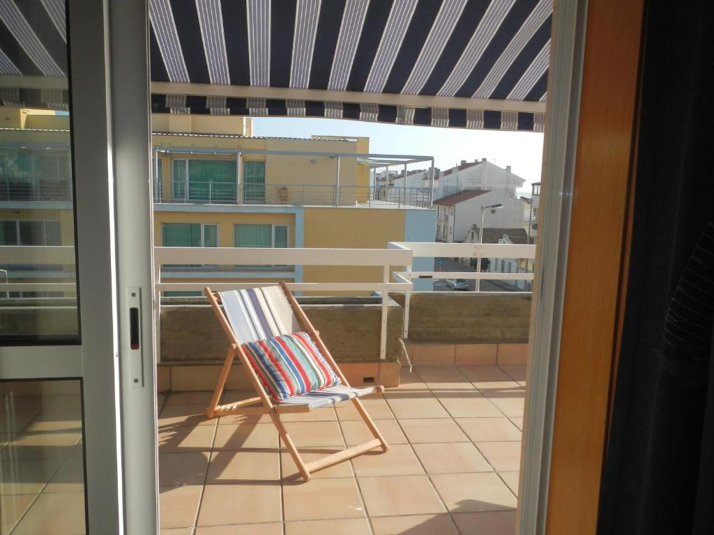 a rocking chair on a balcony with a view at Casa da Barra in Praia da Barra