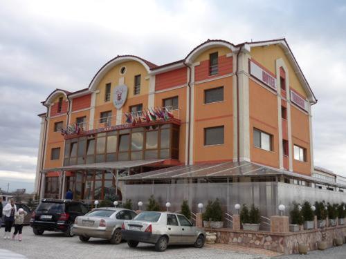 ein großes Gebäude mit davor geparkt in der Unterkunft Hotel Transit in Oradea