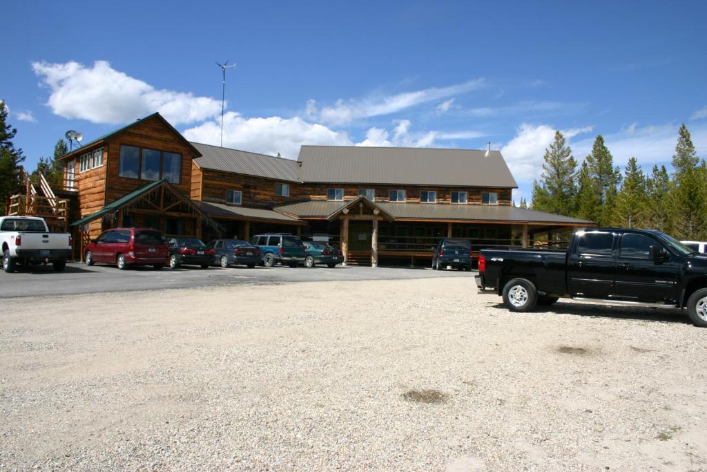 un camion parcheggiato di fronte a una baita di tronchi di Sugar Loaf Lodge & Cabins ad Anaconda