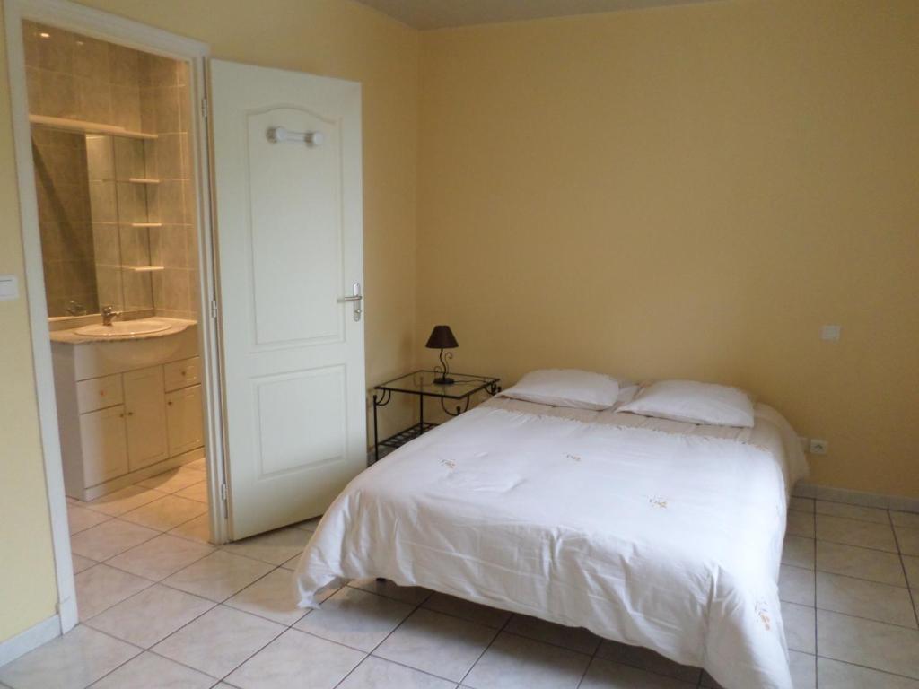 Saint-Didier-sur-ChalaronneにあるMeublé Tourisme 2*のベッドルーム1室(白いベッド1台付)