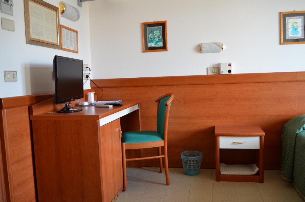 a room with a desk with a monitor and a chair at Hotel Berna in Eraclea Mare