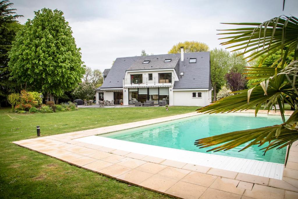 a house with a swimming pool in the yard at Le champ du Renne in Le Mans