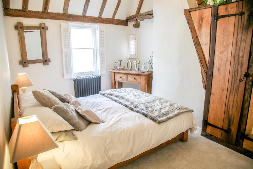 a bedroom with a bed and a wooden door at Stoney Lane in Thaxted