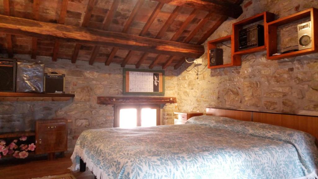 una camera con letto e parete in pietra di Il Borgo dei Laghi a Revine Lago