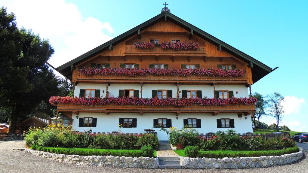 ein großes Gebäude mit Blumen davor in der Unterkunft Landgasthof Fischbach in Wackersberg