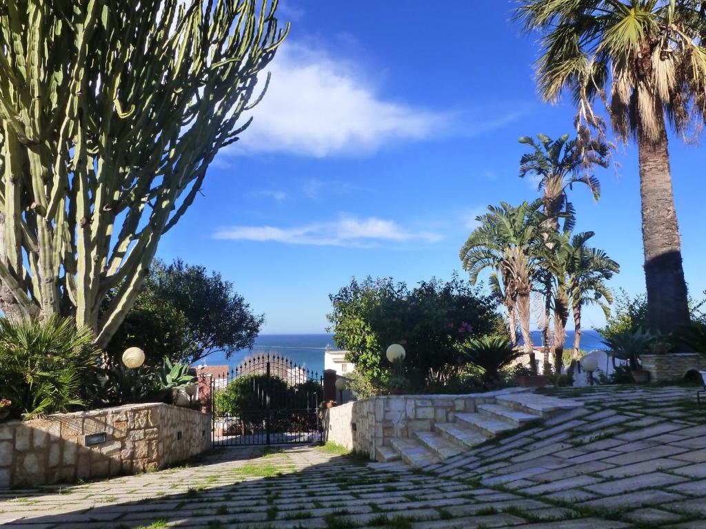 un camino con palmeras y el océano en el fondo en Casa Calendule, en Alcamo Marina