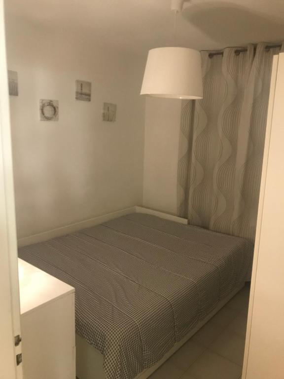a small bed in a room with a lamp at case per vacanze torre incina in Polignano a Mare