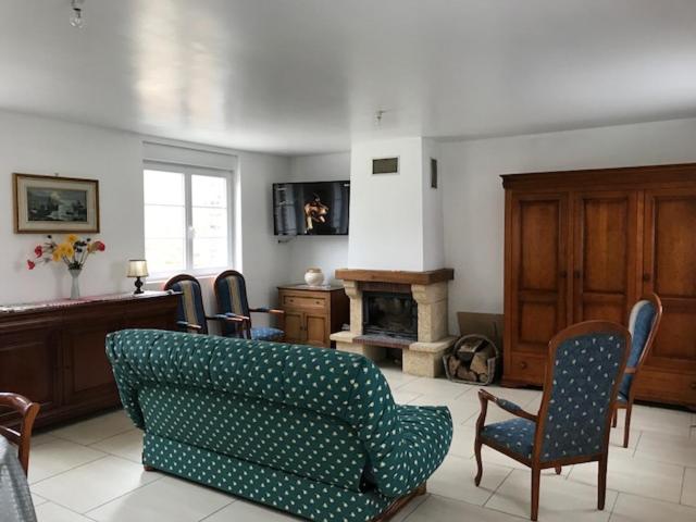 Beaumont-Hamelにあるle clos du caribouのリビングルーム(ソファ、椅子、暖炉付)