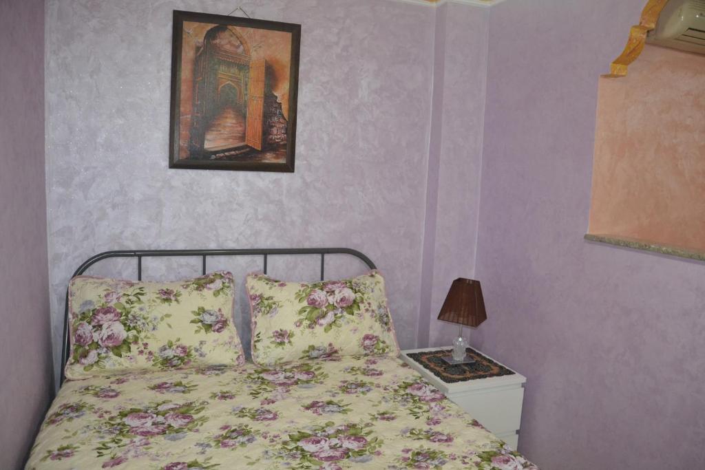 a bedroom with a bed and a picture on the wall at Stay Studio Apartment in Rabat