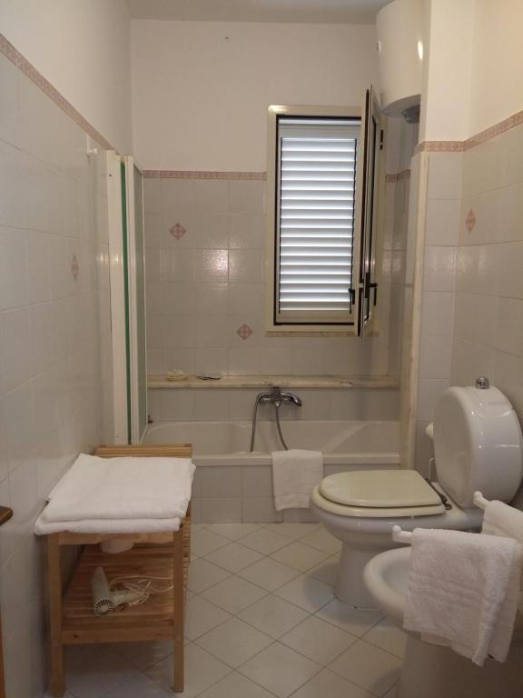 a bathroom with a toilet and a tub and a sink at Akron B&B in SantʼAlessio Siculo