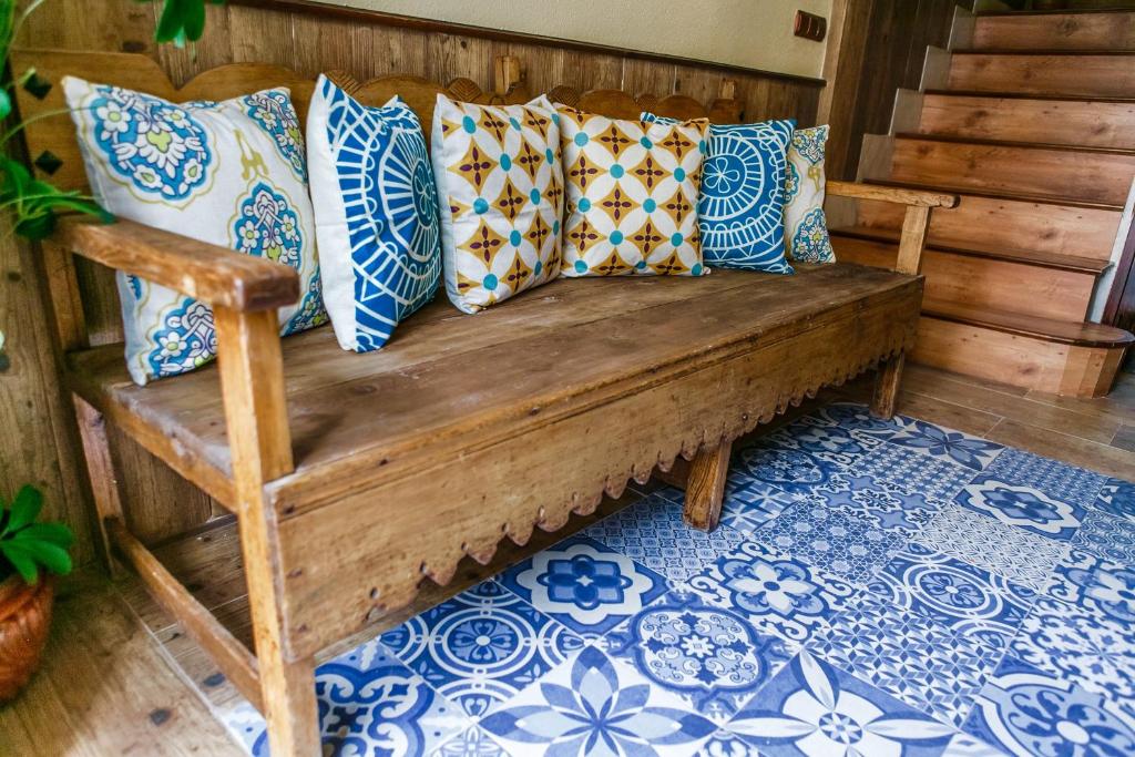 a wooden bench with pillows on it in a room at La Casa del Alfarero - Mejor Villa Sostenible de Europa in Úbeda